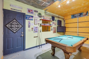 A pool table in a room with a blue door, various posters, and a television on the wall. - Hot Tub & Game Room! Wooded Retreat in Blue Ridge (Blue Ridge)
