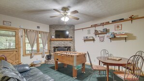 A cozy living room with a foosball table, a television, and a fireplace. - Hot Tub & Game Room! Wooded Retreat in Blue Ridge (Blue Ridge)