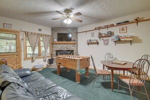 A cozy living room with a foosball table, a television, and a fireplace. - Hot Tub & Game Room! Wooded Retreat in Blue Ridge (Blue Ridge)