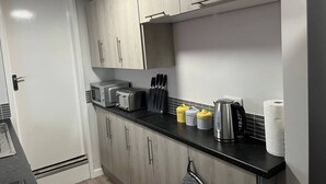 Eine moderne Küche mit schwarzem Arbeitsplatz, Edelstahlgeräten und Holzschränken.