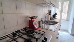 A modern kitchen with a gas stove, stainless steel appliances, and a window providing natural light. - Your home in the historic center of Alatri - 2 bedrooms and 2 bathrooms - pets allowed (Alatri)