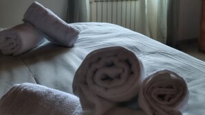 A bed with rolled towels, a window with a view, and a curtain. - Your home in the historic center of Alatri - 2 bedrooms and 2 bathrooms - pets allowed (Alatri)