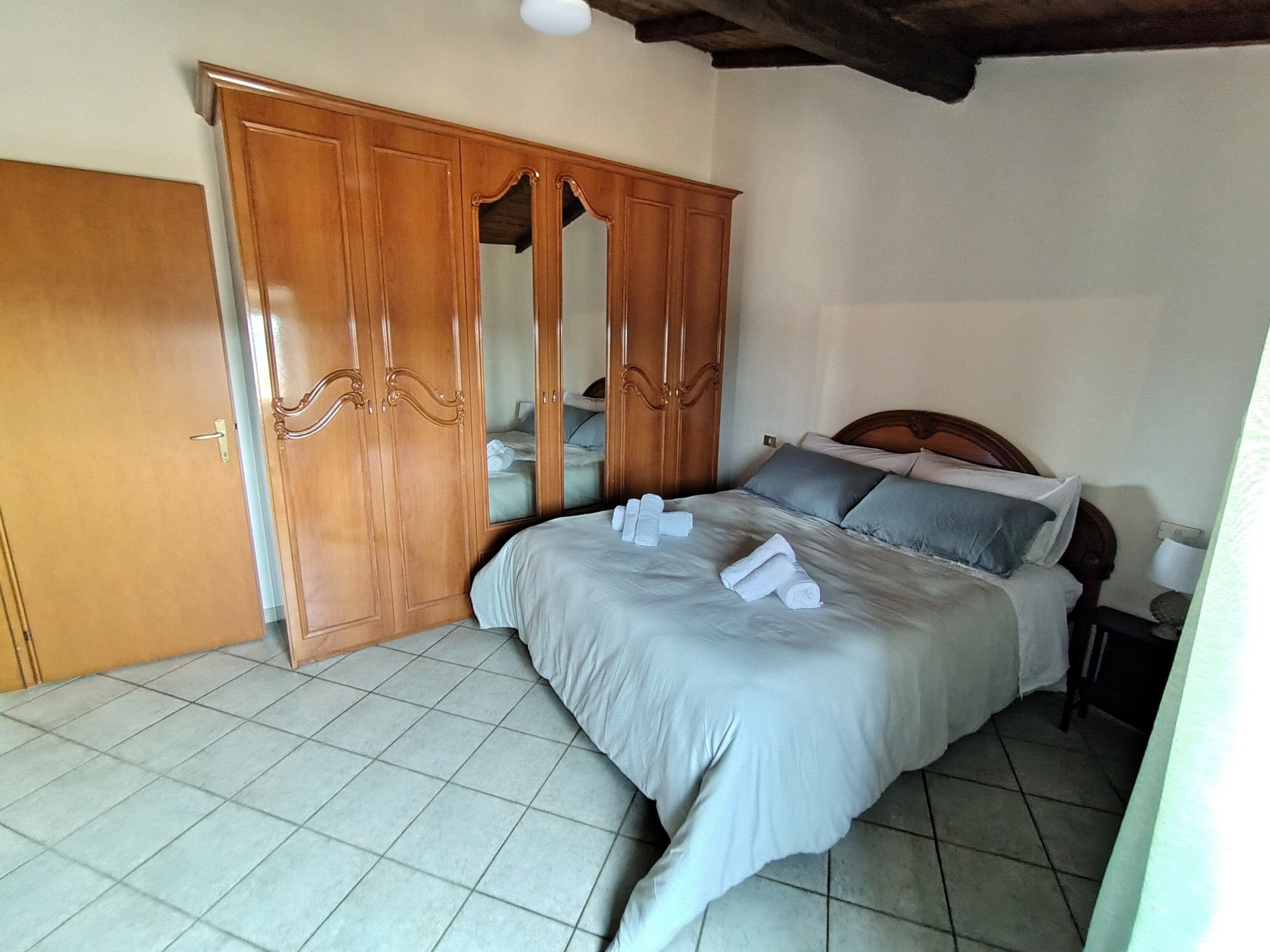 Un dormitorio con una cama, un armario y un espejo.