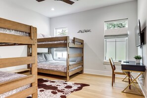 A bunk bed room with a desk and chair, a cowhide rug, and a window with blinds. - Walk to Shore! Family-Friendly Canyon Lake Retreat (Canyon Lake)