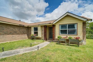 Ein eingeschossiges Haus mit Backsteinfassade, einer Veranda und einem kleinen Vorgarten mit einem Weg zum Eingang.