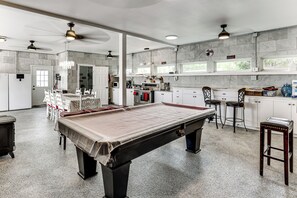 A pool table in a room with a kitchen area, bar stools, and ceiling fans. - One-of-a-Kind Guest Suite in Hill Country w/ Pool (Bulverde)