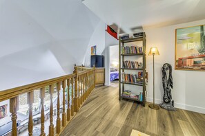 A staircase with wooden railings leading to a bedroom with a bed and a bookshelf. - Experience Staying in Geodome, Pool, Hot Tub, BBQ (Tucson)