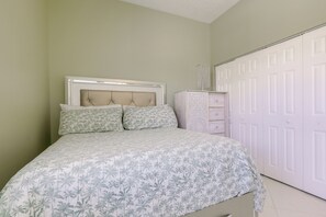 Un dormitorio con cama, cómoda y armario.