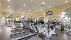 A gym with multiple treadmills, exercise equipment, and large windows allowing natural light. - Trails & Resort Perks! Home in Royal Palm Beach (Royal Palm Beach)