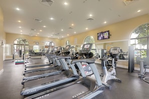 A gym with multiple treadmills, exercise equipment, and large windows allowing natural light. - Trails & Resort Perks! Home in Royal Palm Beach (Royal Palm Beach)