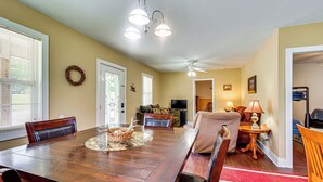 A dining area with a wooden table, chairs, a chandelier, and a ceiling fan. - The Hunter's Retreat at Kudzu Cove Cabins Resort (Guntersville)
