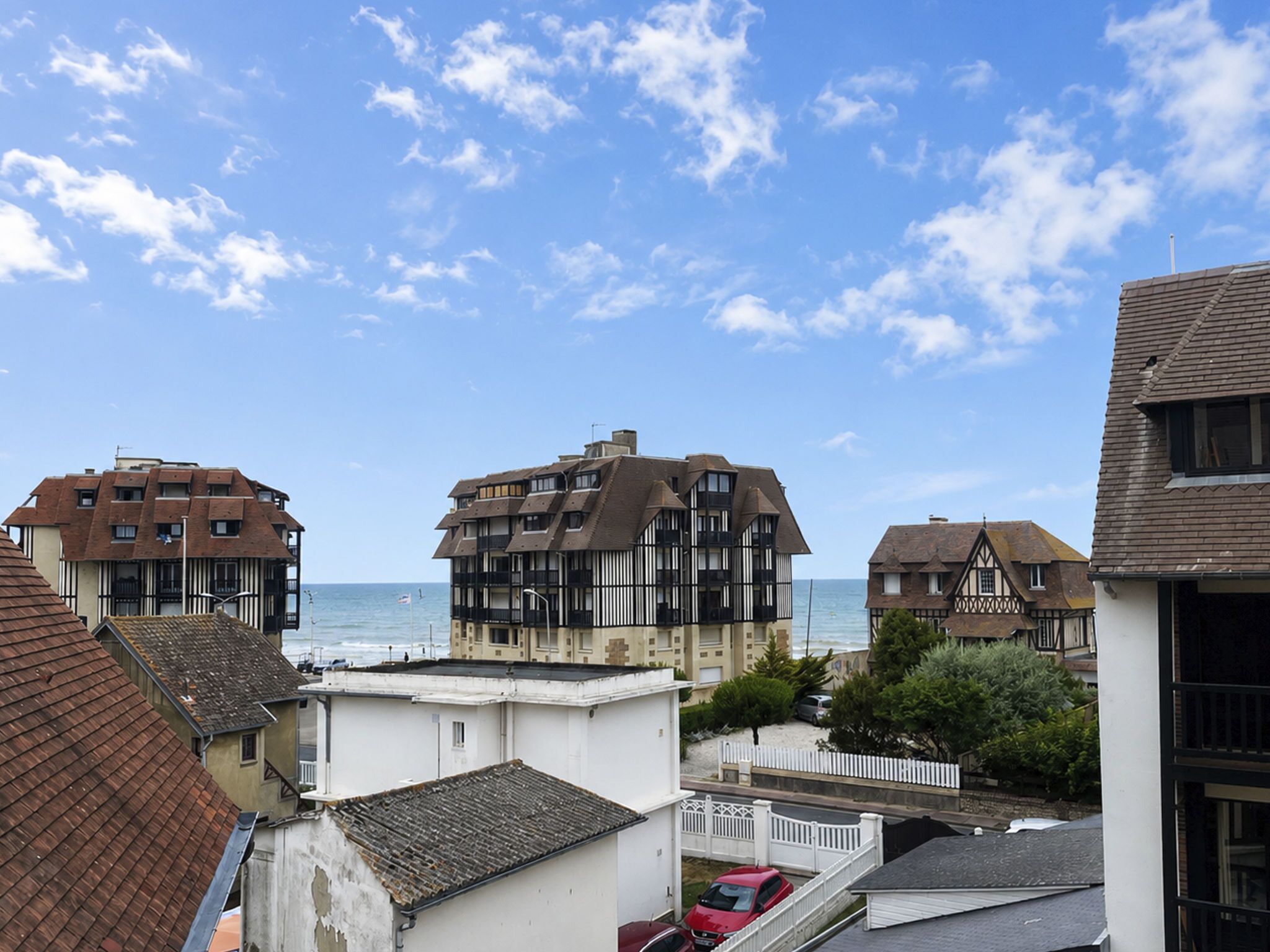 Una zona residenziale costiera con edifici a più piani, una spiaggia ben visibile e cielo sereno.
