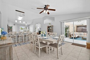 A spacious dining area with a large table, chairs, and a ceiling fan. - Shady Pines Sea-renity | Waterfront Pool & Hot Tub | Golf Nearby | Palm Coast | Close To Beach (Palm Coast)