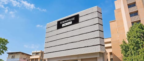 Un edificio moderno con un letrero que dice 'TOWNHOUSE' y 'Serviced'.