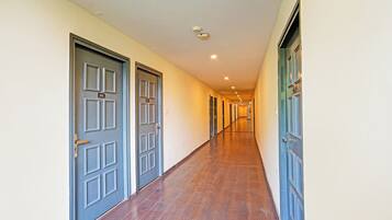 A corridor with doors on both sides, leading to rooms.