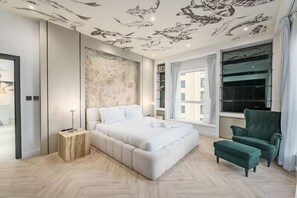 A modern bedroom with a large bed, a green armchair, and a ceiling mural of fish. - FIRST CLASS |2BR| Marina Views | Near JBR Beach (JBR)