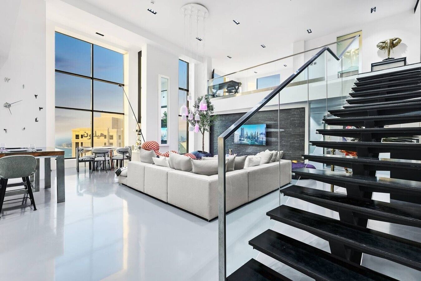 A modern interior with a staircase, a sofa, and a dining area.