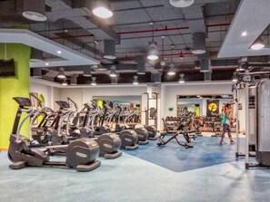 A gym with exercise equipment, mirrors, and a person working out. - FIRST CLASS |3BR| Luxury Duplex w/ Ain Dubai View (JBR)