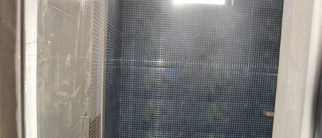 Un bagno con parete piastrellata, un WC e un box doccia.