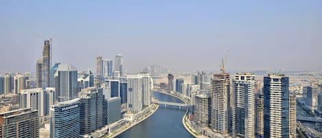 A cityscape with modern high-rise buildings, a river, and a bridge.