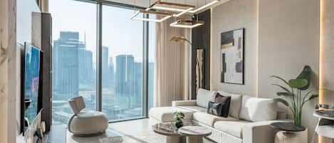 A modern living room with a large window, a sofa, a coffee table, and a TV.