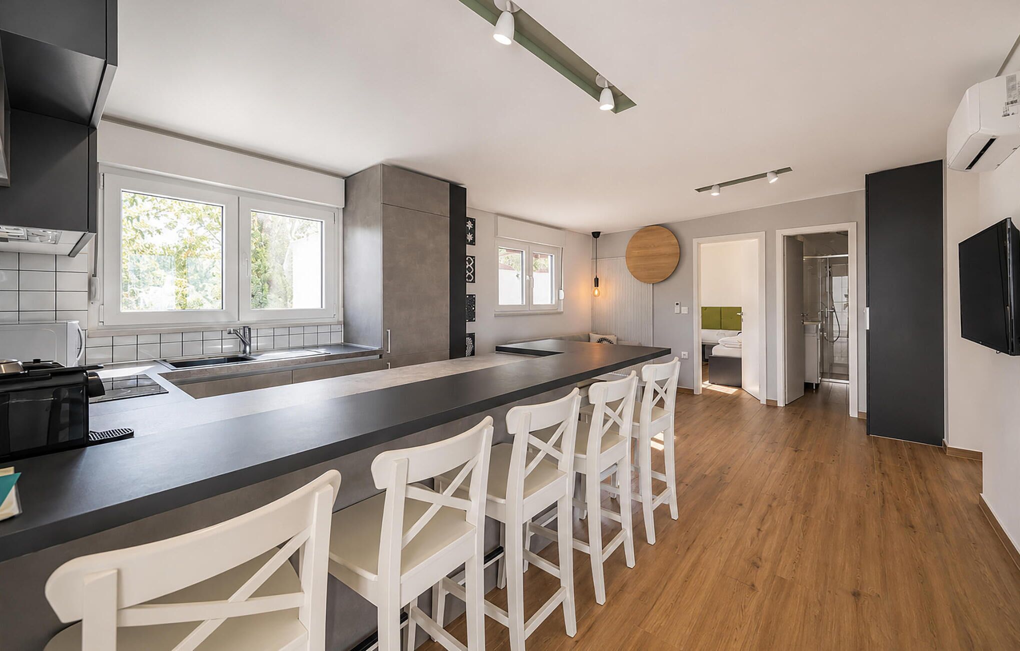 Une cuisine moderne dotée d’un îlot central, de tabourets de bar et d’un coin repas.