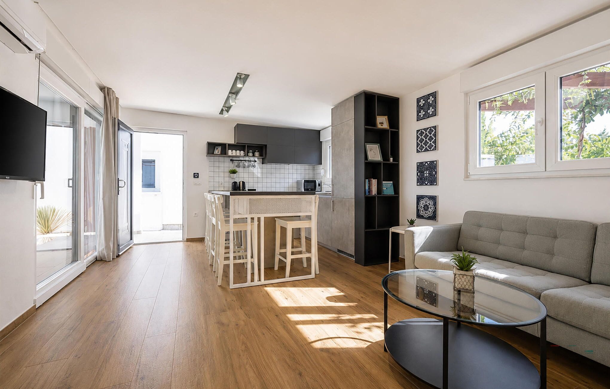 Eine moderne Küche mit einer zentralen Kochinsel, einem Essbereich mit Stühlen, einer Couch und einem Couchtisch.