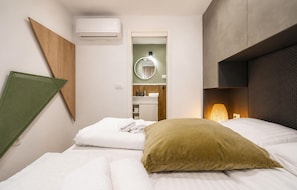 A hotel room with a bed, a pillow, an air conditioning unit, a mirror, and a wall-mounted shelf. - Amazing home in Zerava (Zerava)