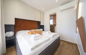 A hotel room with a bed, bedside tables, and a wardrobe. - Beautiful home in Zerava (Zerava)