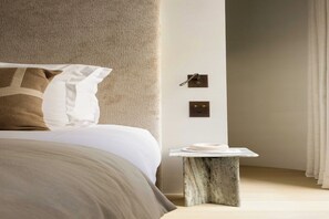 A modern bedroom with a bed, a marble nightstand, and a wall-mounted light switch. - Luxurious suite - AC- 2P- Madeleine/Saint Honore (Paris)