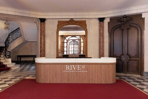 A reception desk with a checkered floor, a staircase, and a large wooden door. - Luxurious suite - AC- 2P- Madeleine/Saint Honore (Paris)