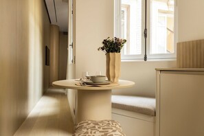 A narrow hallway with a round table and a vase of flowers. - Luxurious suite - AC- 2P- Madeleine/Saint Honore (Paris)
