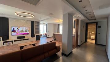 Un hall d’hôtel moderne doté d’un espace salon, d’un téléviseur à écran plat et d’un comptoir d’accueil.