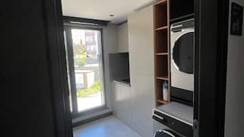 A modern kitchen with built-in appliances, a large window, and a view of the outside.
