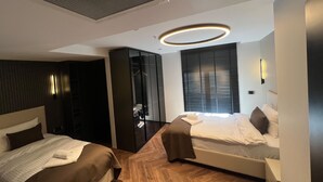 A modern hotel room with a bed, a wardrobe, and a built-in closet. - Vela Blu Suites (Trabzon)