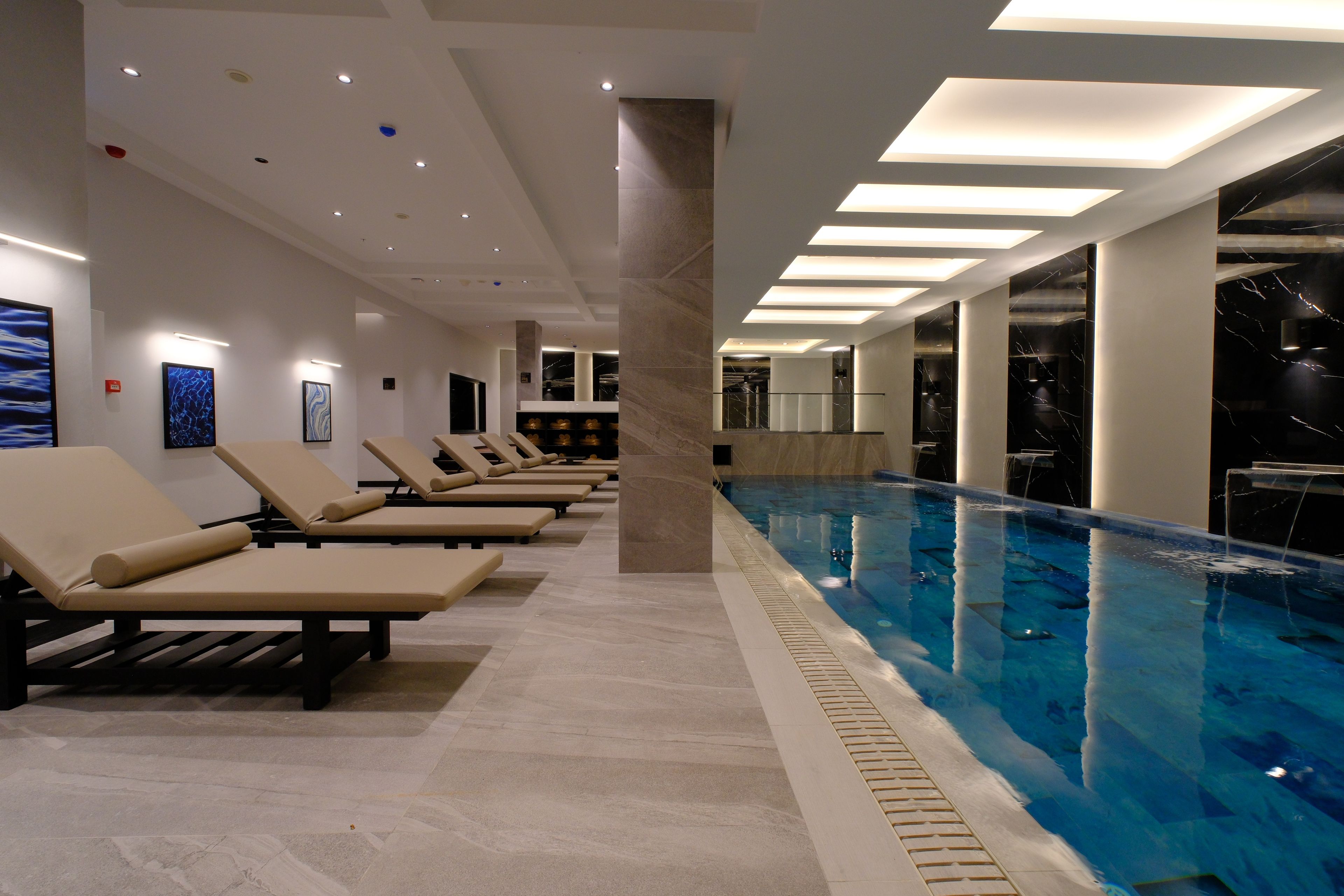 A swimming pool with lounge chairs and a modern interior design.