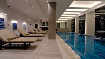 A swimming pool with lounge chairs and a modern interior design.