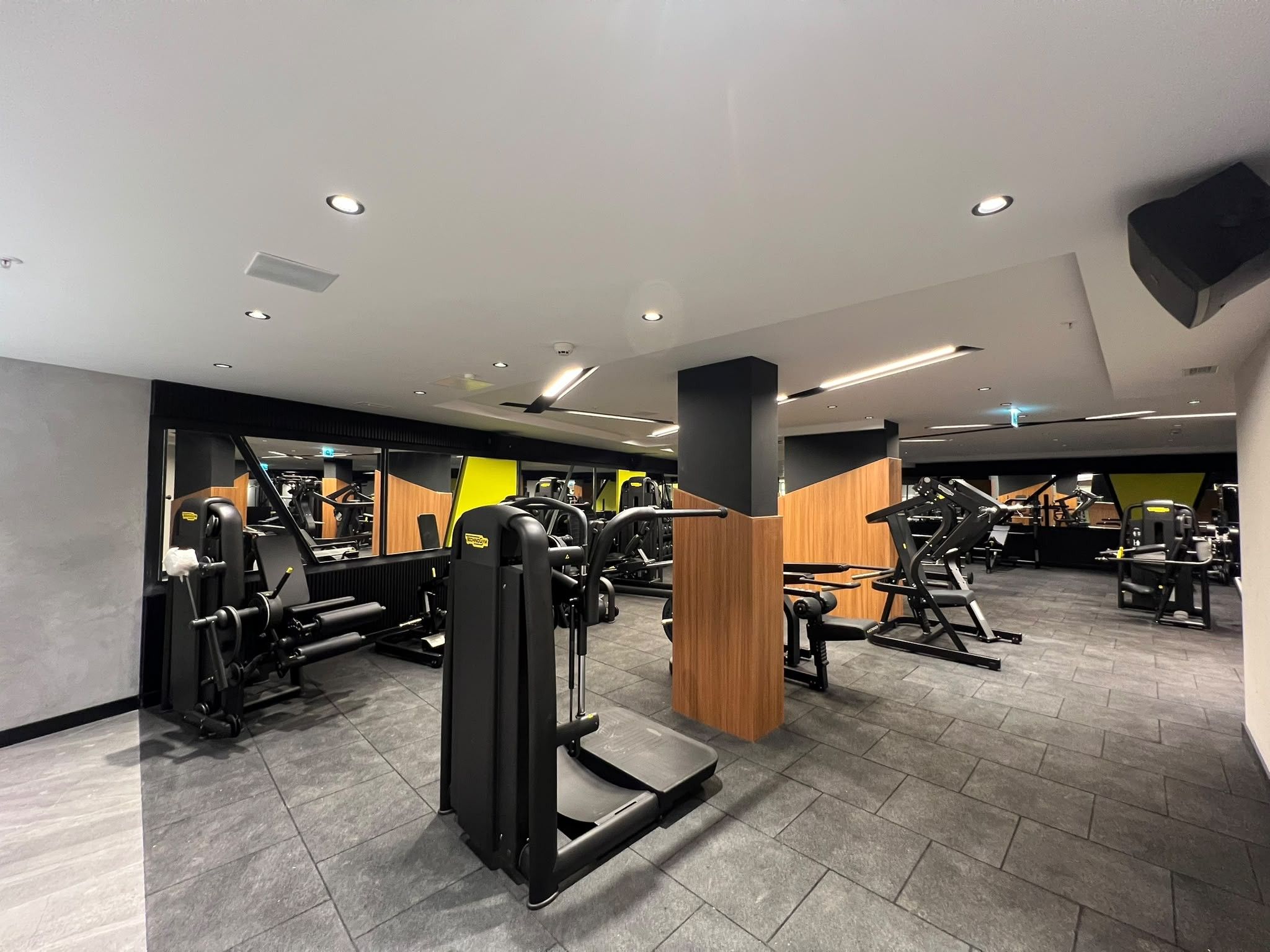 Un gimnasio moderno con diversos equipos de ejercicio, que incluye máquinas de pesas y cintas de correr.