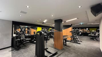 Un gimnasio moderno con diversos equipos de ejercicio, que incluye máquinas de pesas y cintas de correr.