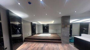 Une salle de bain moderne avec un plancher en bois, une baignoire et des murs en marbre.