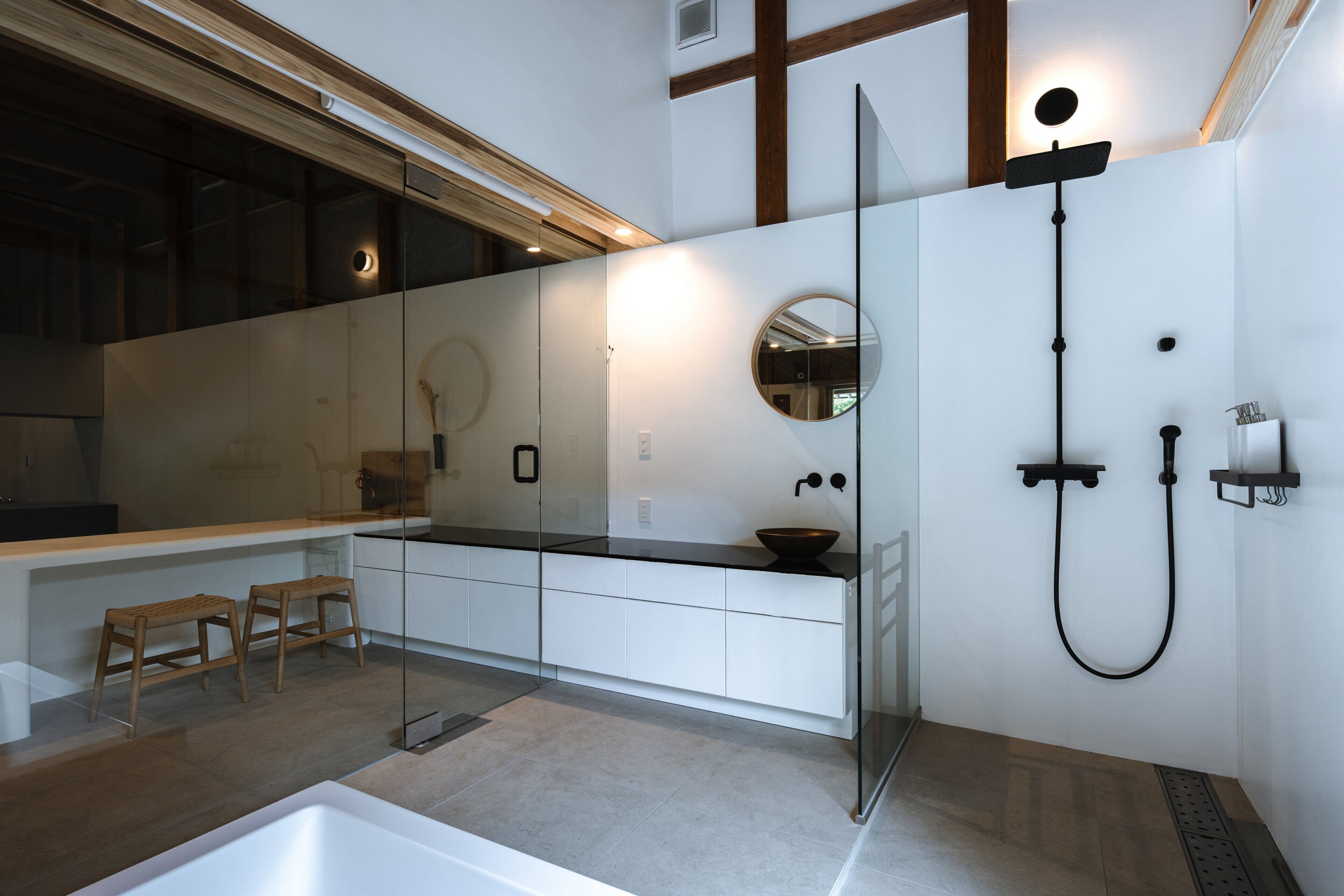 Ein modernes Badezimmer mit einer Duschkabine aus Glas, einer weißen Badewanne und einem großen Spiegel.