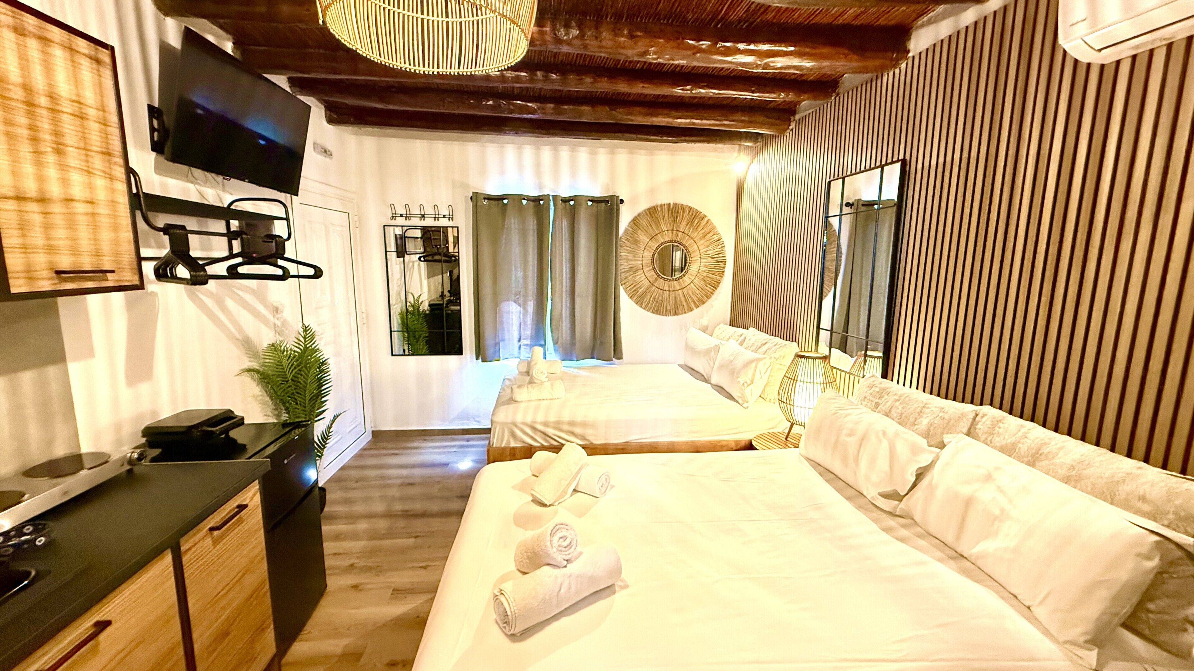 Een hotelkamer met een bed, een bureau, een televisie en een spiegel.