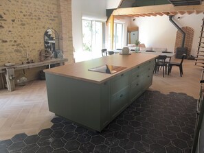 A kitchen with a central island, a dining area with chairs, and a staircase. - Fully renovated country house (Barville)