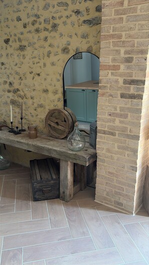 A rustic interior with a stone wall, a wooden bench, a blue cabinet, and a tiled floor. - Fully renovated country house (Barville)