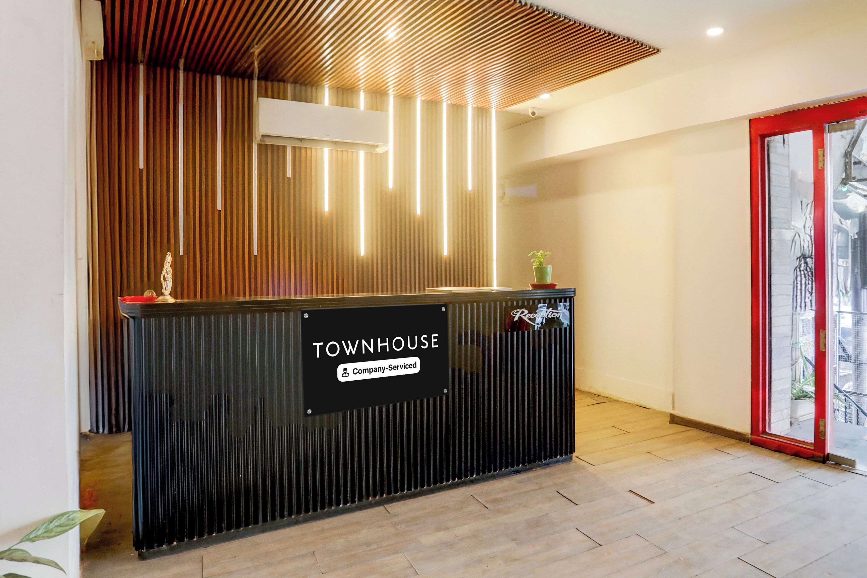 A reception desk with a sign reading 'TOWNHOUSE Company Serviced.'