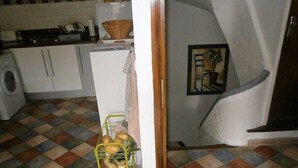 A kitchen with a tiled floor, a white refrigerator, and a yellow bread rack. - The perfect getaway on the square in Saint-Chinian, home to its famous wine (Saint-Chinian)