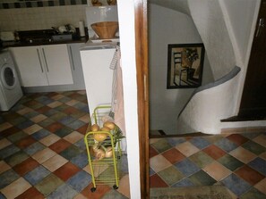 A kitchen with a tiled floor, a white refrigerator, and a yellow bread rack. - The perfect getaway on the square in Saint-Chinian, home to its famous wine (Saint-Chinian)