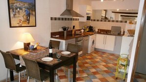 A compact kitchen with a dining area, a microwave, a sink, and a washing machine. - The perfect getaway on the square in Saint-Chinian, home to its famous wine (Saint-Chinian)