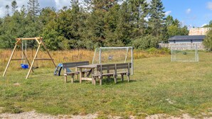 Ein Spielplatz mit Schaukeln, einer Bank und einem Fußballtor.