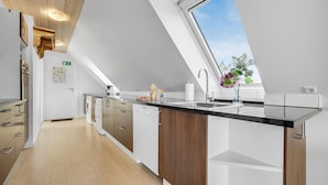 Eine moderne Küche mit Oberlicht, Einbaugeräten und Blick zum Himmel.